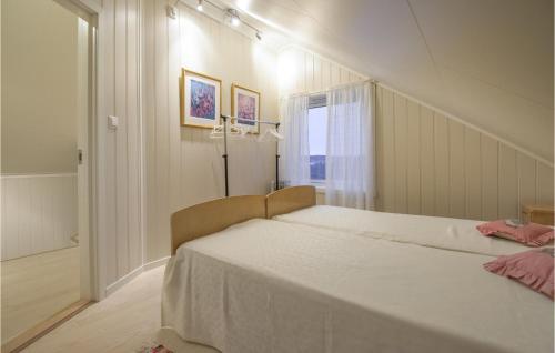 斯托克马克内斯Beautiful Home In Stokmarknes With House A Panoramic View的卧室配有一张大白色床和窗户