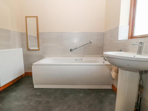 瓦利Arwelfa的浴室配有白色浴缸和水槽