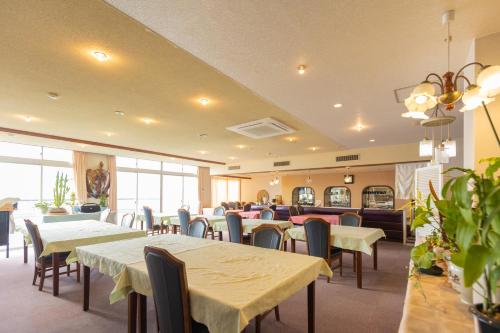 Sakurajima樱岛海滨酒店的配有桌椅和桌上电脑的用餐室