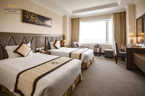 荣市穆尔泰东方大酒店的酒店客房设有两张床和窗户。