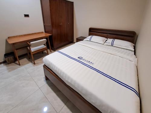 哥打京那巴鲁Global Residency的一张大床,位于一个配有书桌和一张四柱床的房间