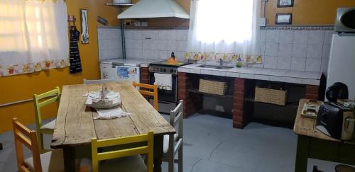 NaicóEl Trébol Casa de Campo的厨房配有木桌、椅子和炉灶