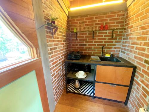 龙目岛库塔Comfortable Wood House second floor and attic的一个带水槽和砖墙的小厨房