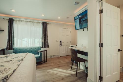 莫罗贝Blufftop Inn & Suites - Wharf/Restaurant District的一间卧室配有一张床、一张桌子和一台显示器