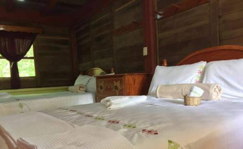 CABAÑAS CEYTAKS的一间卧室设有两张带白色床单的床和窗户。