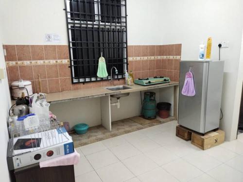BalingSacha Permai Homestay的厨房配有柜台、水槽和冰箱。