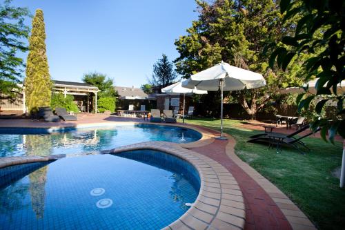 伊丘卡伊丘卡港美居酒店的一个带遮阳伞和庭院的大型游泳池