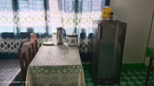 ItaytayUstaris Homestay的厨房配有桌子、冰箱和窗户