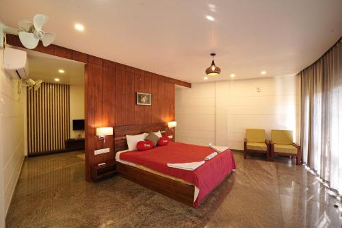 ThirunelliMayookham的一间卧室配有红色的床和桌椅
