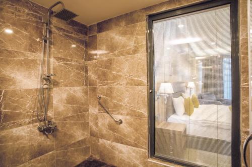 伯萨Royal Termal Hotel的带淋浴的浴室和玻璃门