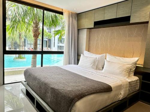 卡马拉海滩Kamala Beach Pool view Resort P15的一间卧室设有一张大床和一个大窗户