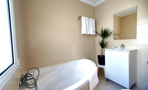 奥维多La Luz de Acevedo的白色的浴室设有浴缸和水槽。