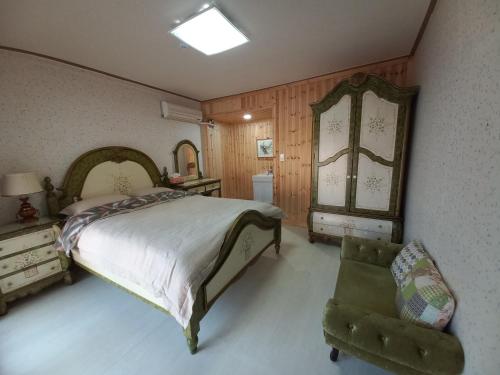 安东市Wolyeongchae的一间卧室配有一张床、一把椅子和镜子