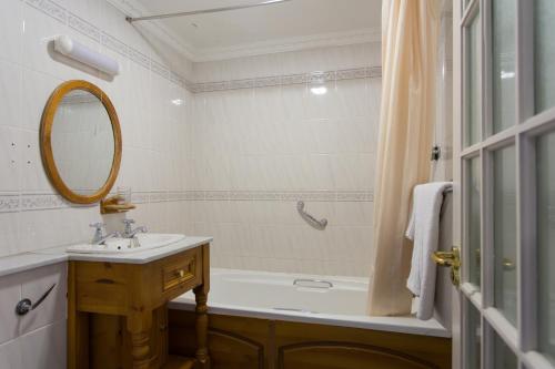 拉斯诺拉沙屋酒店的一间带水槽、浴缸和镜子的浴室