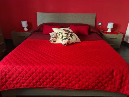 卡利亚里Affittacamere Sa Pardula的红色的床,上面有红色的床单和枕头