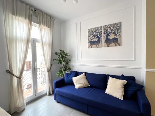 瓦伦西亚Maritime Apartamentos Valencia的客厅设有蓝色沙发,配有窗户