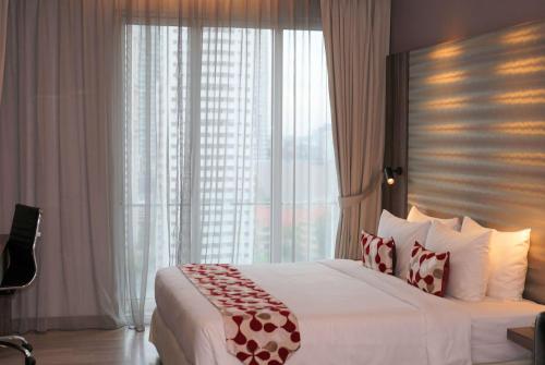 吉隆坡吉隆坡市中心华美达套房酒店的一间卧室设有一张大床和一个大窗户