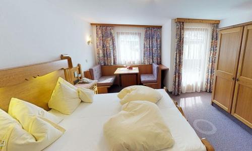 图克斯玫瑰园旅馆的卧室配有一张带黄色枕头的大型白色床。