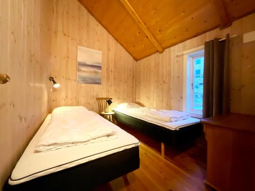 索尔瓦根The blacksmith's place - Cozy Rorbu in Lofoten的配有木墙和窗户的客房内的两张床