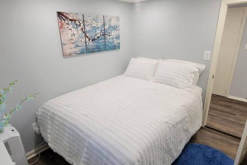 尤宁戴尔Cheerful 2-Bedroom Apartment with Smart Home Tech.的卧室配有一张白色床,墙上挂有绘画作品
