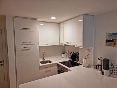 卡拉米洛Cozy apartment with a fantastic sea view的厨房配有白色橱柜和水槽