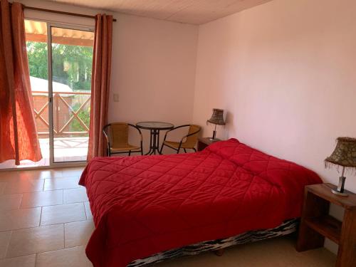 拉佩德雷拉Posada Cova Del Sol的一间卧室配有红色的床和桌椅