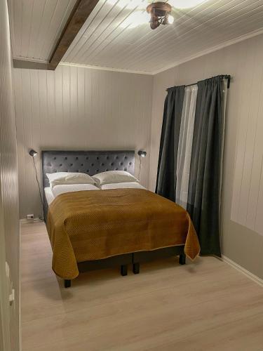 勒罗斯Villa Gulstua的一间卧室配有一张带窗帘的大床