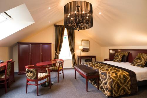特文Hof de Draeck Bed & Breakfast的一间卧室配有一张床、一张书桌和一个吊灯。