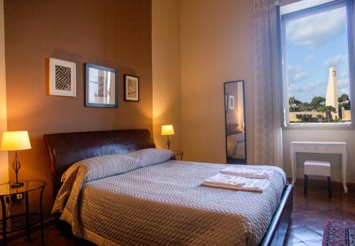 布林迪西B&B Regina Margherita的一间卧室配有一张床,窗户带有塔楼