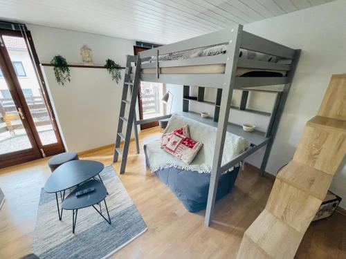 梅塔比耶Au Doubs Village的客房设有双层床、桌子和椅子。