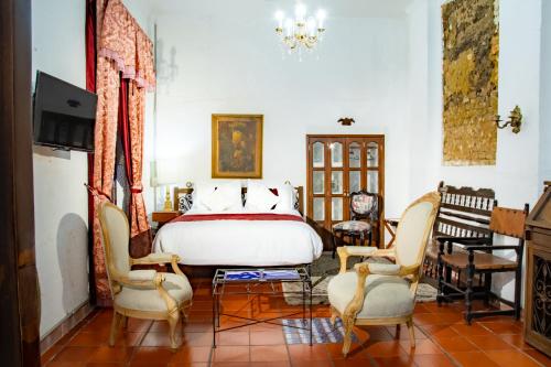 波哥大Hotel Casa de la Luz的一间卧室配有一张床和两把椅子