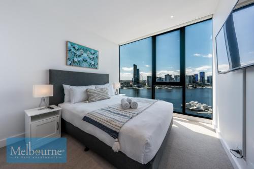 墨尔本Melbourne Private Apartments - Collins Wharf Waterfront, Docklands的一间卧室设有一张床和一个大窗户