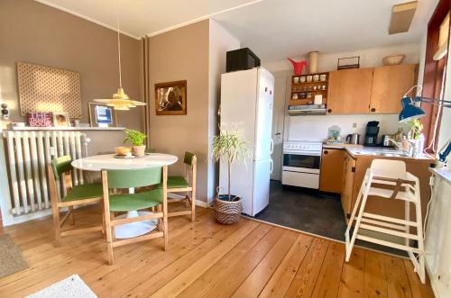 兰讷斯En hel lejlighed i midtbyen - centralt, hyggelig og tæt på alt!的厨房配有桌子和白色冰箱。