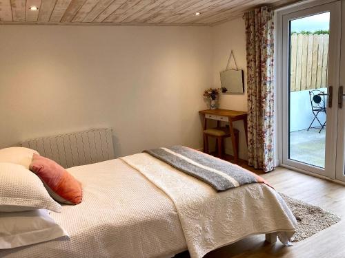 GortahorkThe Birdhouse with Hot Tub的一间卧室设有一张床和一个滑动玻璃门