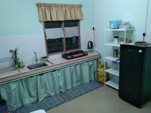 哥打巴鲁Ruhani Homestay 2 Kota Bharu Cheap and Comfortable的厨房设有水槽和窗户。