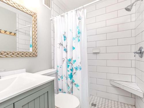 泰比岛Beach Racquet A126的白色的浴室设有淋浴帘和卫生间。