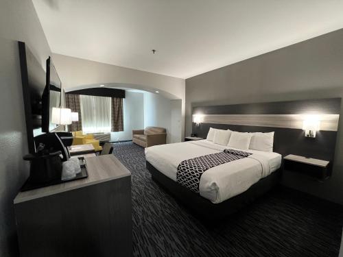 艾伦艾伦拉昆塔乡村套房酒店的酒店客房设有一张大床和一张书桌。