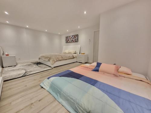 蒙特利尔4 Bedrooms Beautiful Townhouse的一间白色客房,配有一张床,一间卧室配有一张床。