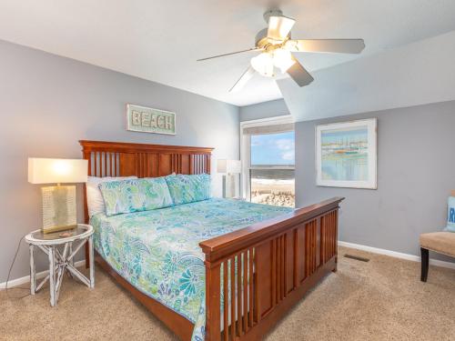 泰比岛Tybee Lights 110C的一间卧室配有一张床和吊扇