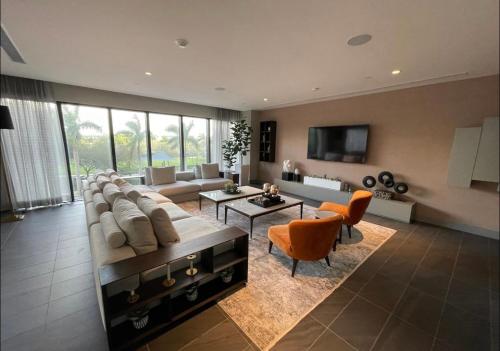 迈阿密5350 Park inn Suite的大型客厅设有大沙发和橙色椅子