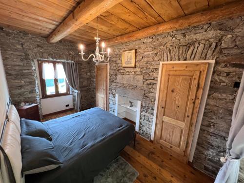 MontecresteseAppartamento completamente ristrutturato的一间卧室设有一张床和石墙