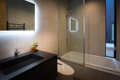 白马村Prominence by The Hakuba Collection的一间带水槽、浴缸和卫生间的浴室