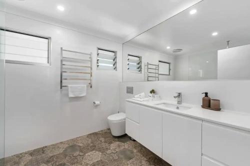 黄金海岸Broadbeach Bungalow - Heated Pool - Sleeps 7的白色的浴室设有卫生间和水槽。