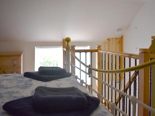 ClenchwartonThe Snuff Box的一间卧室设有两张床和楼梯栏杆。