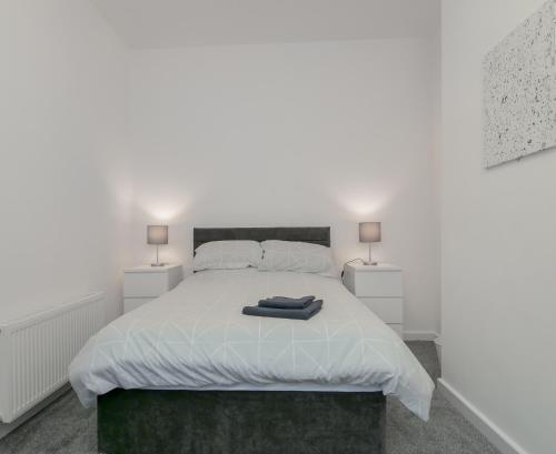 Apex Living NE - Carnegie House 4 Bed House, FREE PARKING FREE WiFi的卧室配有带两盏灯的白色床