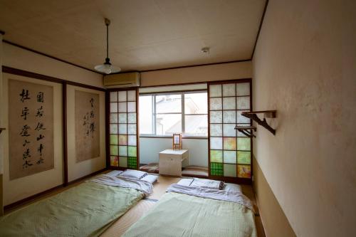 京都宝恩旅馆的带窗户的客房内的两张床