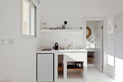 特拉维夫Isla apartment's的白色的厨房配有水槽和镜子