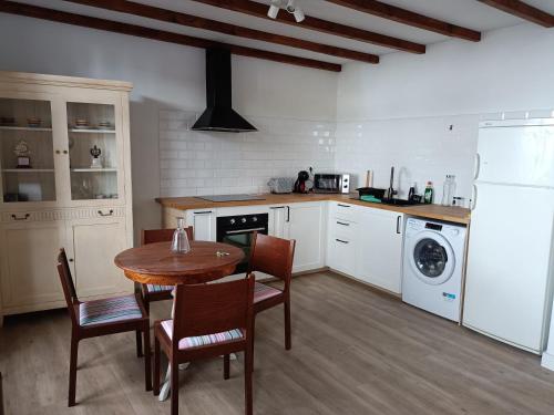丰卡连特德拉帕尔马Casa Las Enanitas II (Casa Elias)的厨房配有桌椅、洗衣机和烘干机