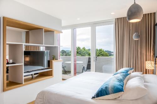 盖塔里布里克特尼亚酒店的一间卧室设有一张带电视的床和一个阳台。