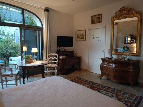 希农Gîte la comète的一间卧室配有一张床、一张书桌和一面镜子